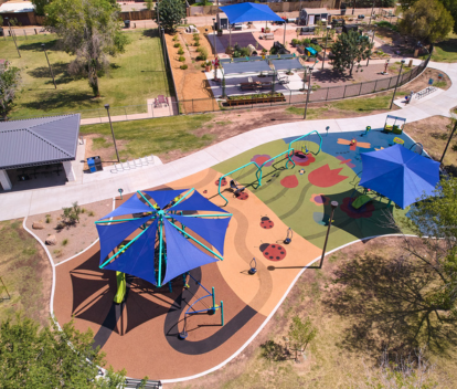 Aerial photo of Clark Park showing two playground areas with artist design rubber surface, two shade sails, a community garden and a ramada.
