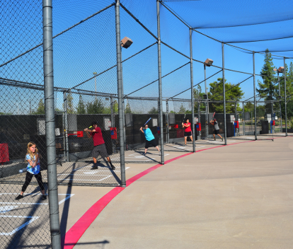 Kiwanis Batting Range filled with youth hitting softballs