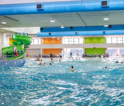 Photo of the Kiwanis Wave Pool and slide with people in tubes floating on the waves.