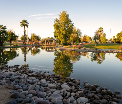 Photo of the lake at Selleh Park at sunset with trees in the background.